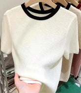 Blusa feminina canelada com gola redonda e mangas curtas em tecido flexível e macio, estilo minimalista e ajuste perfeito.